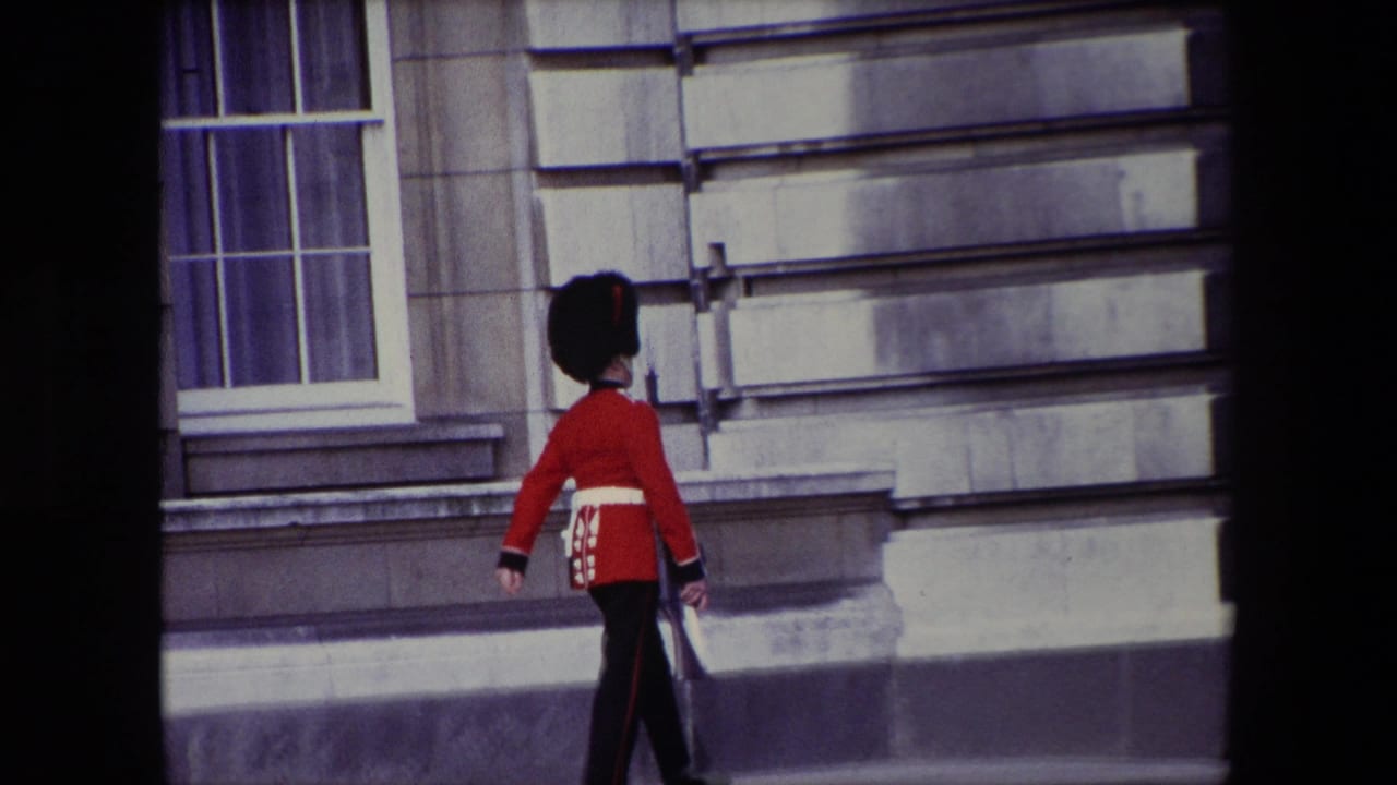 Uniformed guard walking along the building exterior with rifle at his side.