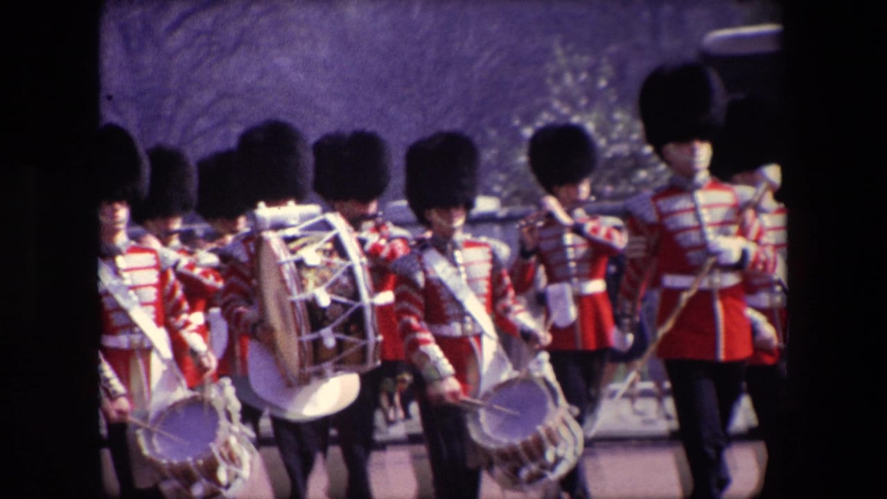 Closer rear view of uniformed drummers marching in formation on the street.