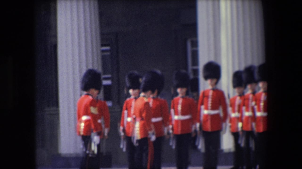 Rows of red-uniformed guards stand and turn near a columned building.
