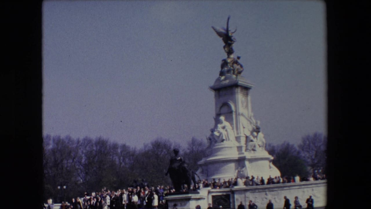 Tall stone monument with visitors gathered below and bare trees in the background.