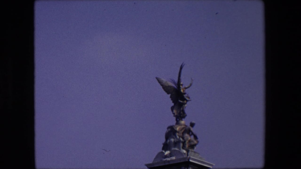 Winged statue on a stone monument seen against open sky.