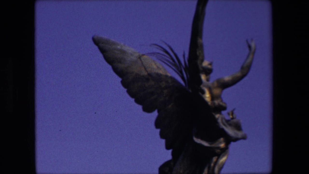 A winged statue detail in London appears against a blue sky in grainy 1967 8mm home-movie footage.