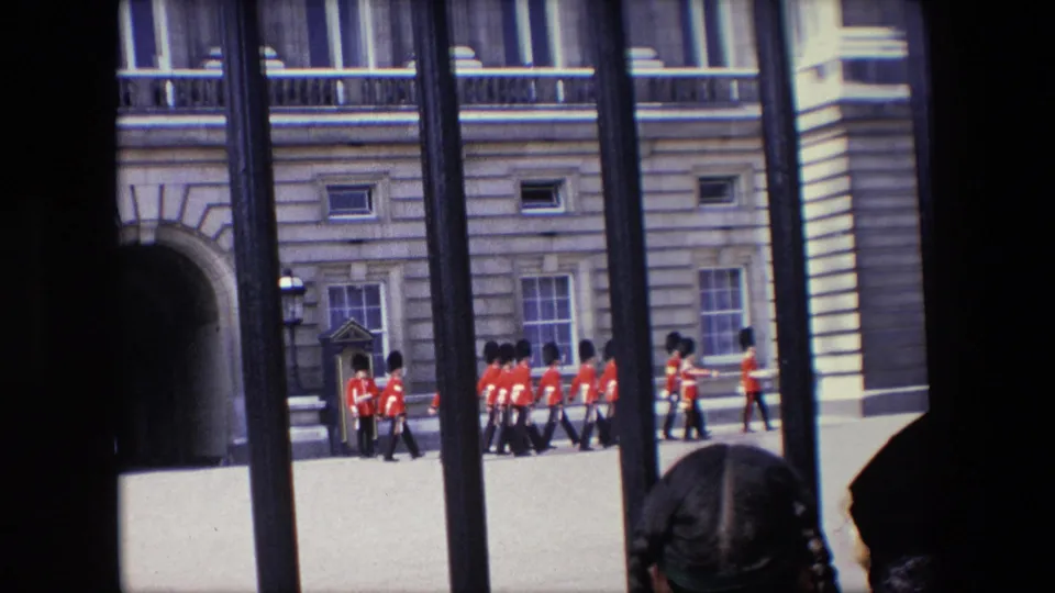 Buckingham Palace guards and nearby visitors are visible through black railings in a visitor-shot 1967 London 8mm frame.