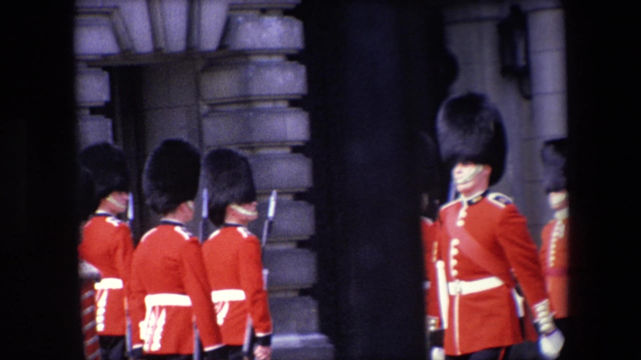 Red-uniformed guards stand near a stone building exterior.