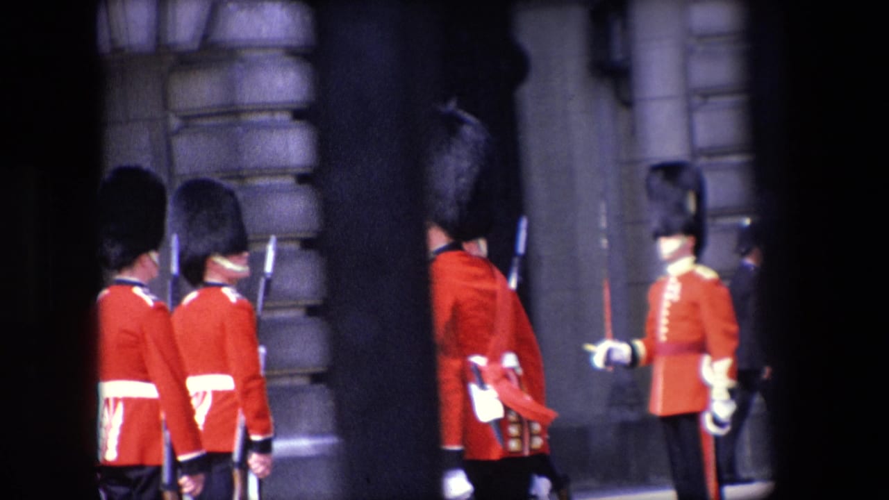 Uniformed guards stand and turn near a building entrance.