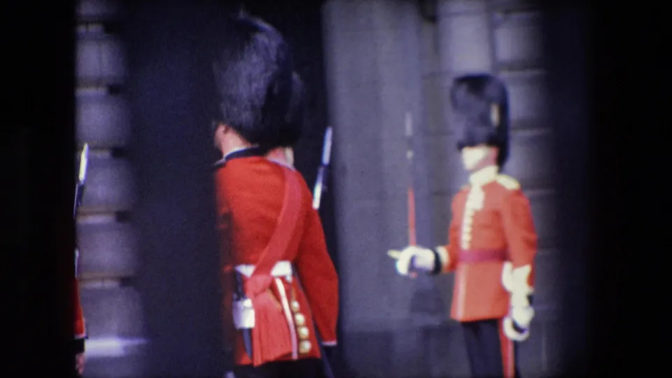 The final frame shows red-uniformed guards in tall dark hats near a London stone building exterior, with one figure seen from behind and another in profile.
