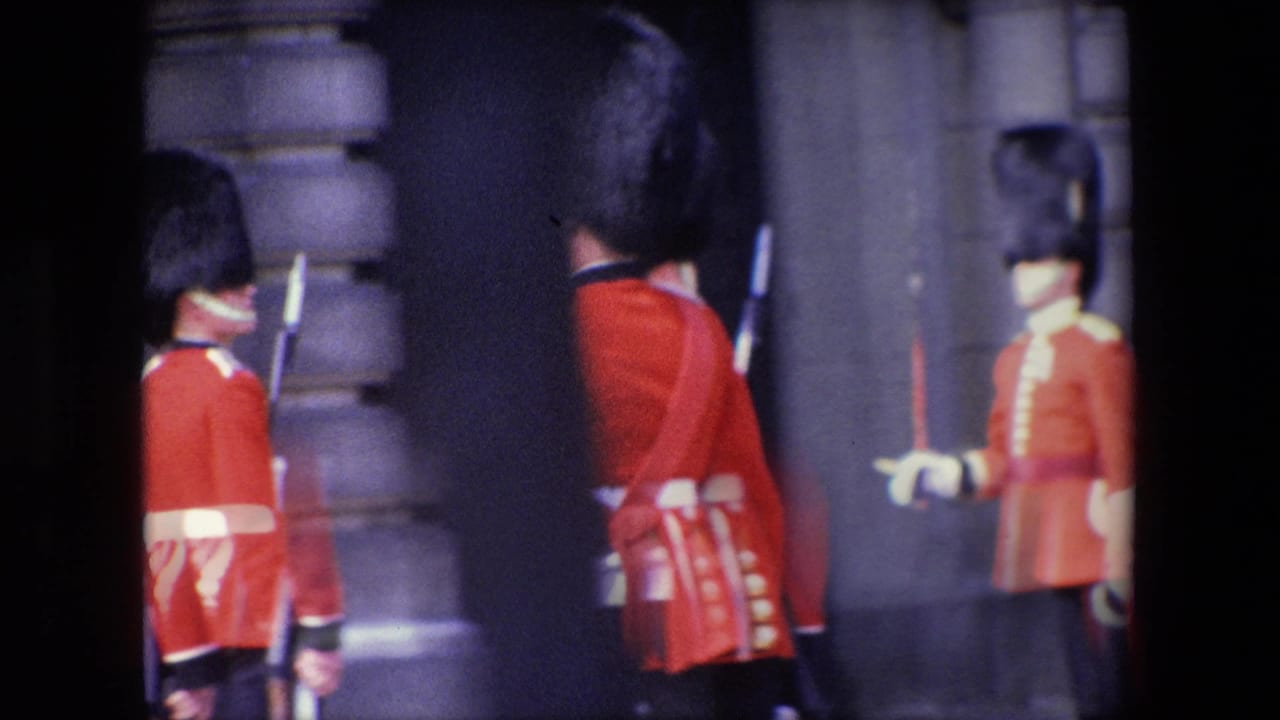 Uniformed guards in red tunics stand near a stone building with rifles visible.