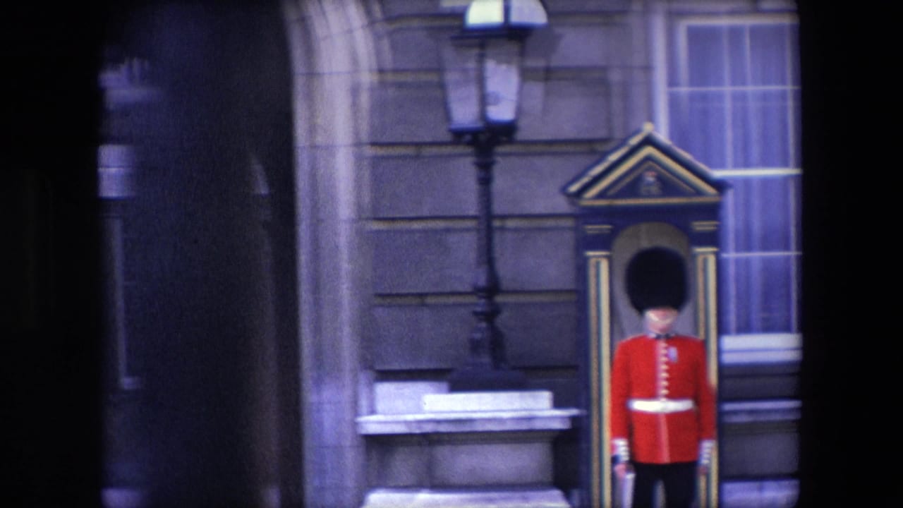 Royal guard standing at attention beside a sentry box against a stone building facade.