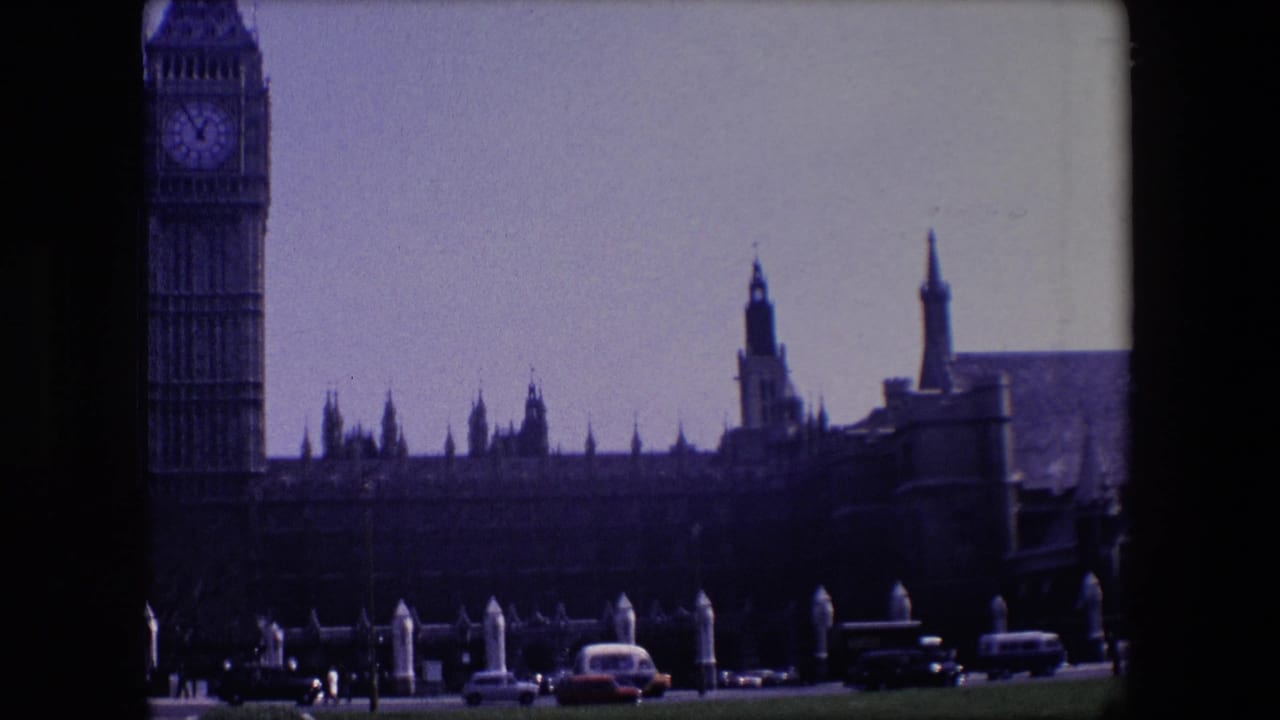 Big Ben and Westminster buildings behind traffic on a London street.
