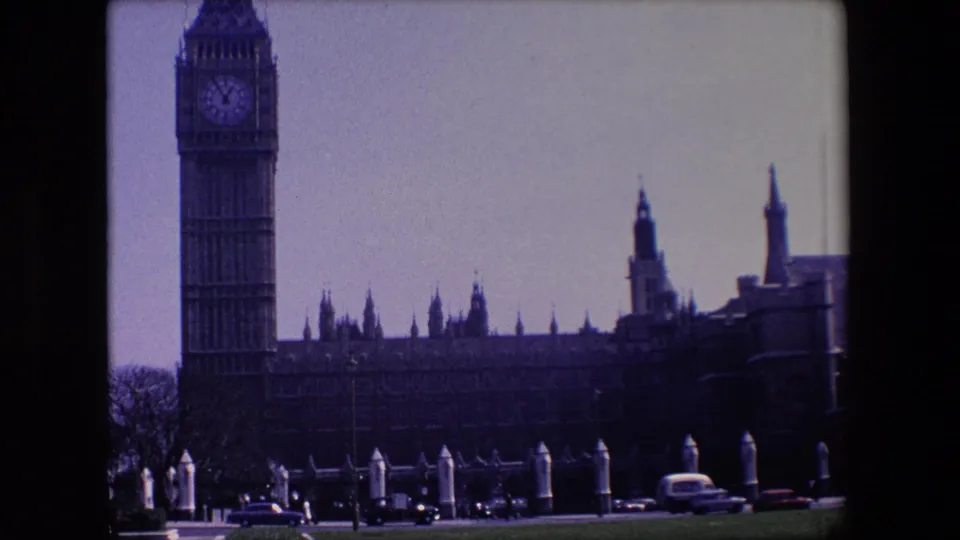 London street traffic moves below Big Ben and the Palace of Westminster in a 1967 home-movie frame.
