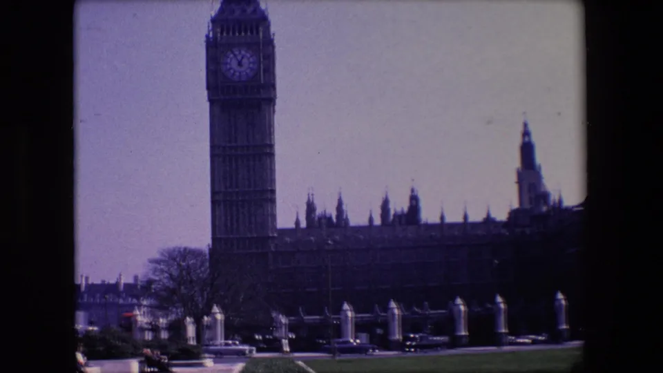 1967 8mm frame with Big Ben centered over Westminster buildings and traffic visible along the lower edge.