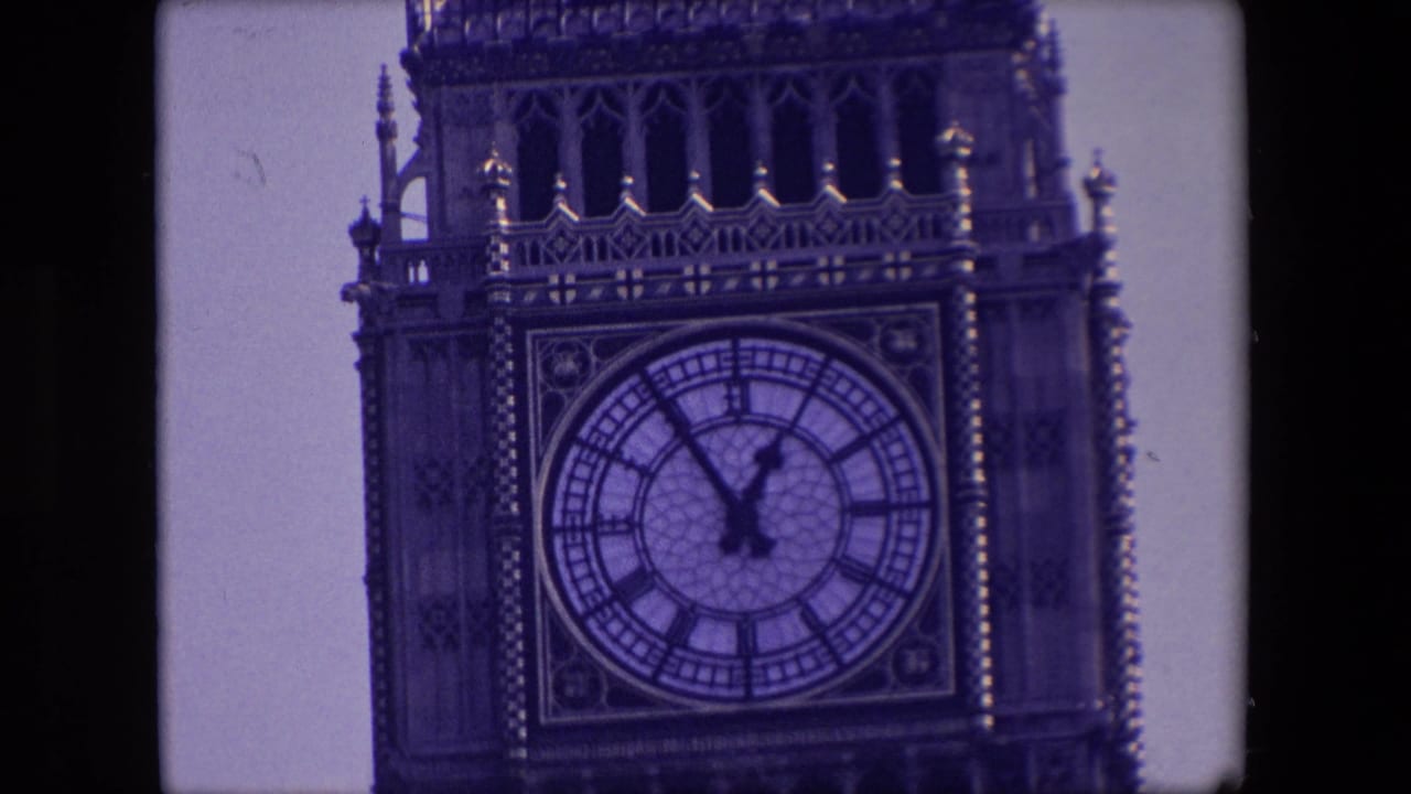 1967 London frame with a tighter view of the Elizabeth Tower clock dial, Roman numerals, clock hands near five to one, and ornate stonework.