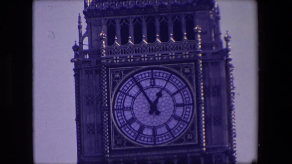 1967 London frame with a tighter view of the Elizabeth Tower clock dial, Roman numerals, clock hands near five to one, and ornate stonework.