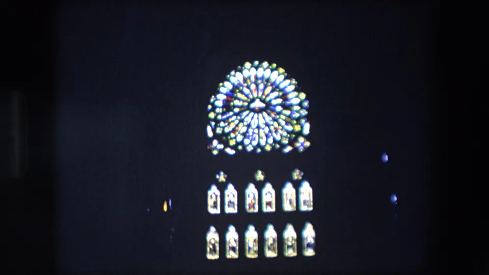 Final 1967 London frame with the glowing circular architectural or clock detail slightly right of center above rows of lit arched panels in deep darkness.