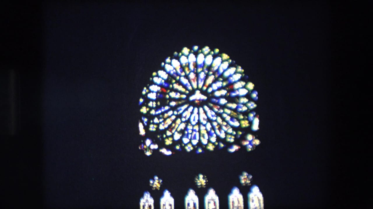 Bright circular stained-glass window with lower panes in darkness.