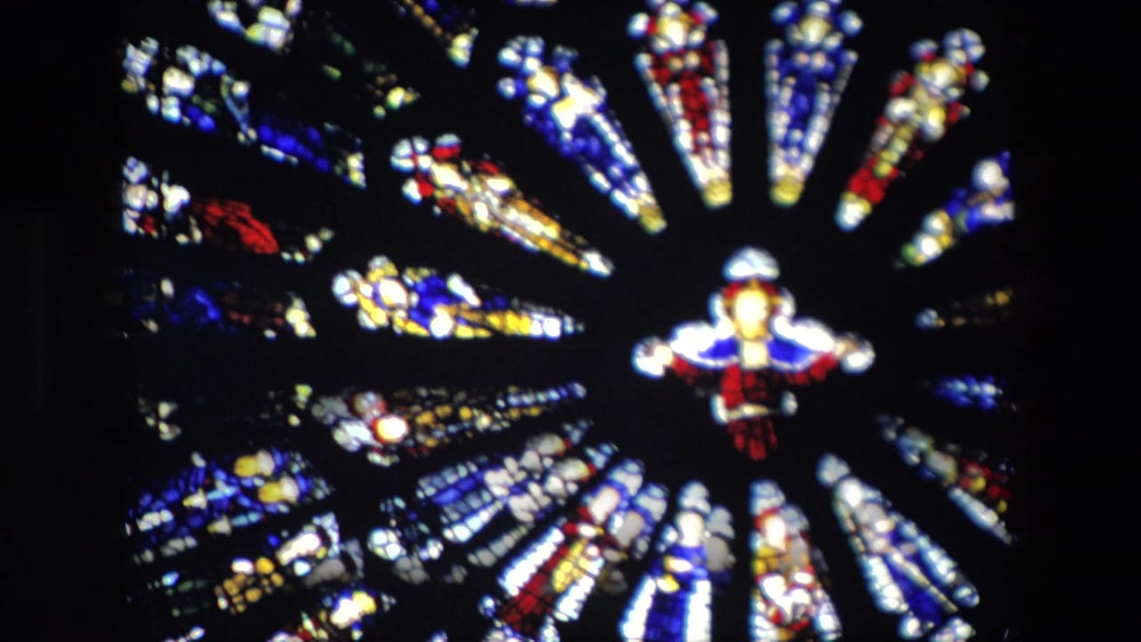 Circular stained glass window detail with bright colored panels and black lead lines.