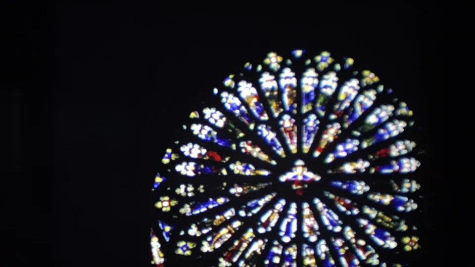 1967 London frame showing the stained glass window from farther back, with the circular design isolated in a mostly black interior field.