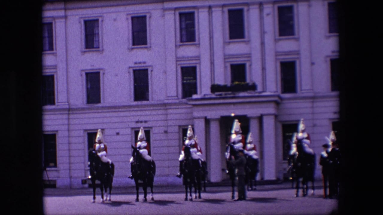 In supplied 1967 London footage, mounted cavalrymen in red and metal full-dress uniforms line up before a pale building facade.
