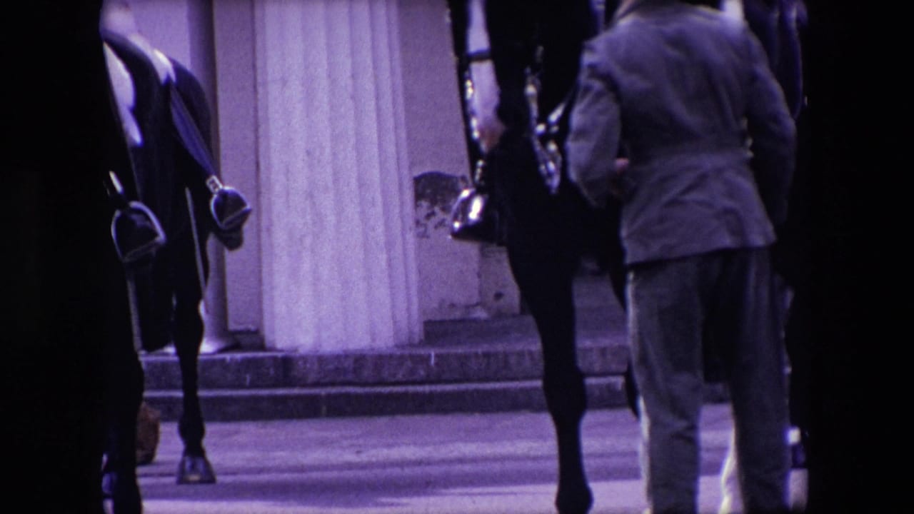 Mounted soldiers and a bystander near stone columns.