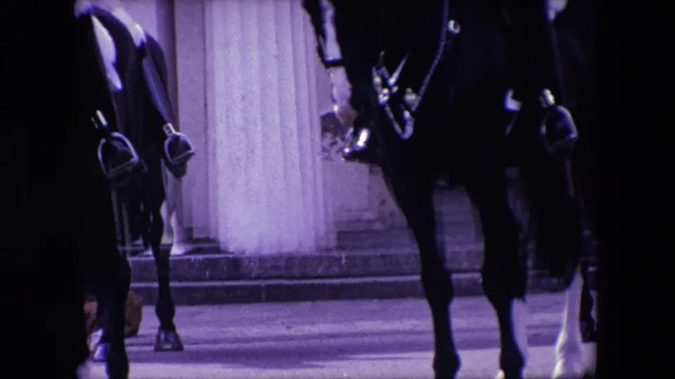 Close 1967 London home-movie view of mounted horses, stirrups, bridles, and column bases, with riders mostly cropped from the frame.