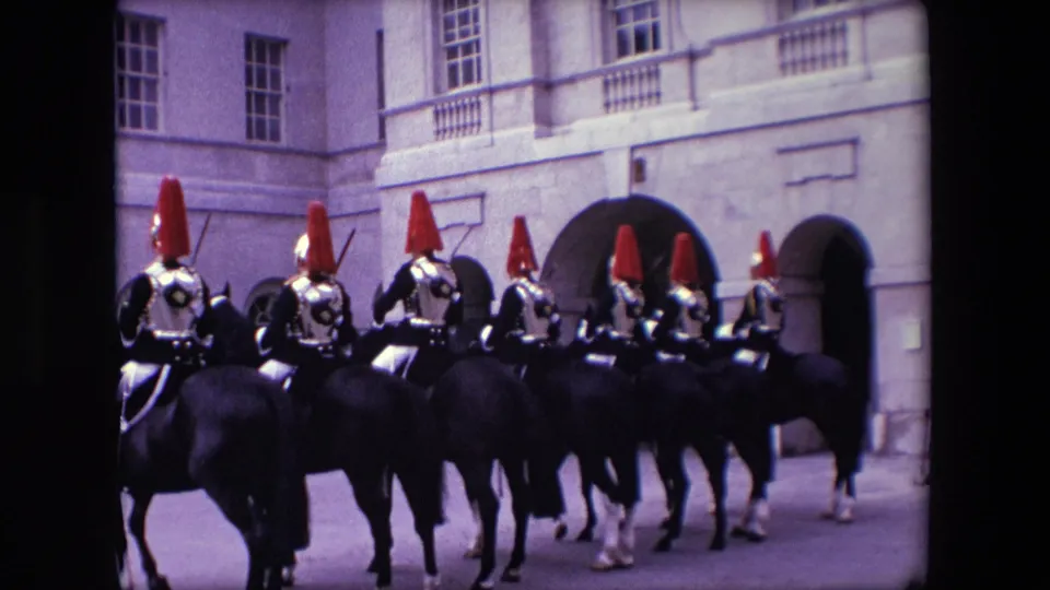 The closing frame shows a compact group of ceremonial horsemen in red plumed helmets riding before a large stone building, consistent with the supplied 1967 London location.