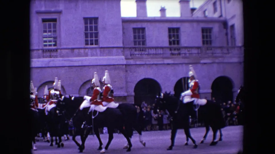 A closer 1967 London view shows mounted guards in plumed helmets and red uniforms passing the camera, with a spectator line and stone arches in the background.