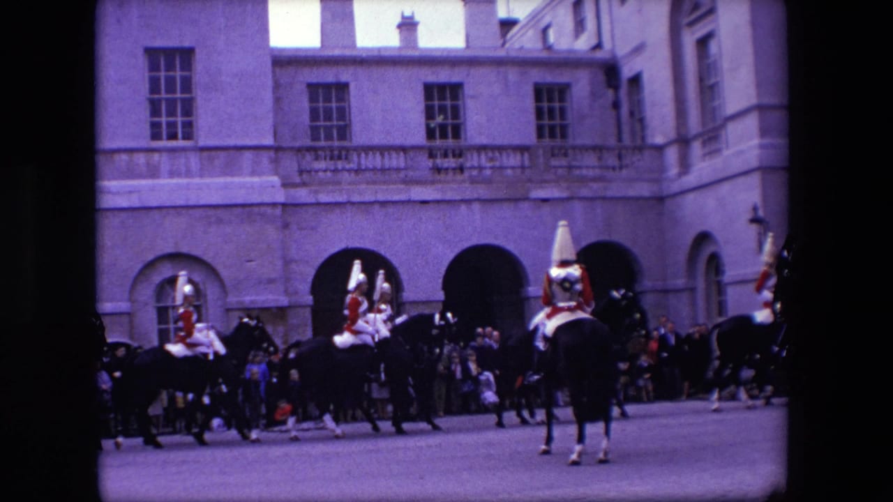 Uniformed riders on horses move across a public viewing area with a crowd behind them.