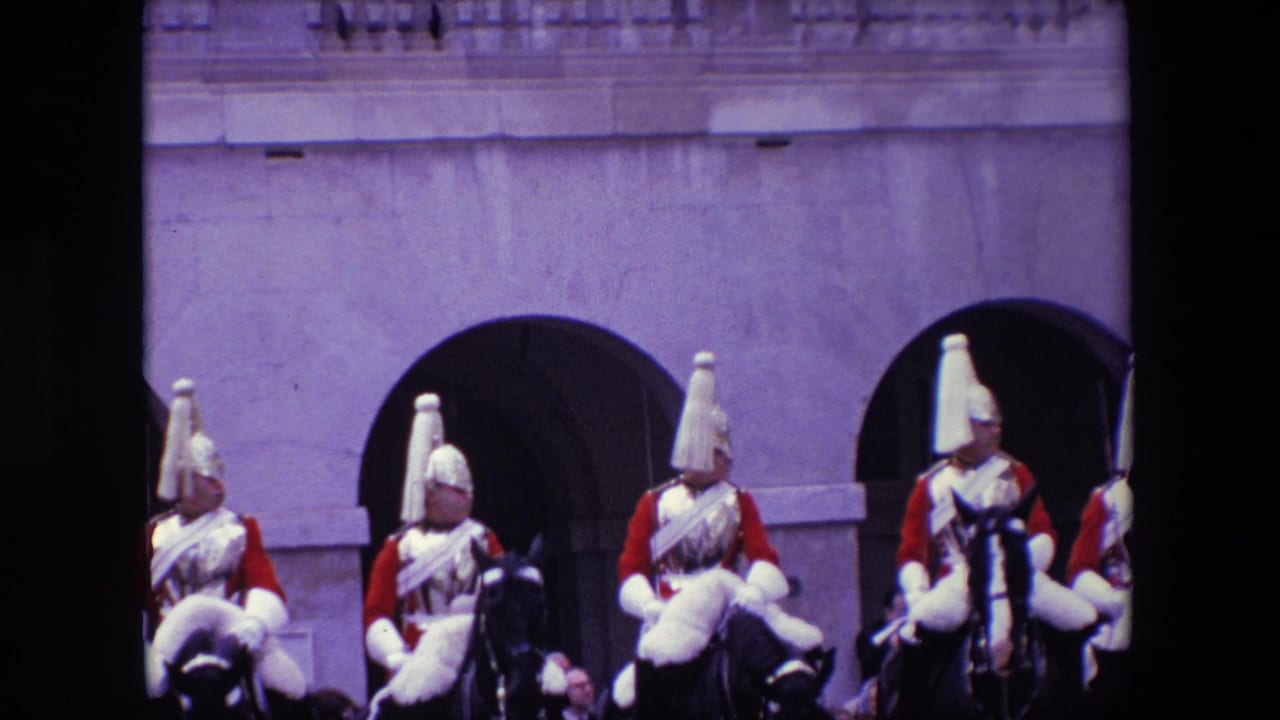 Closer view of mounted guards in red uniforms and plumed helmets near arched stone openings.