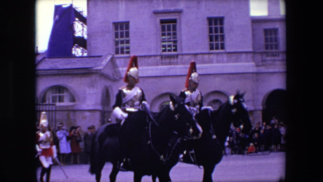 In London according to the supplied 1967 metadata, mounted ceremonial soldiers with red plumes, polished breastplates, helmets, and swords ride side by side past a crowd in a pale stone courtyard.
