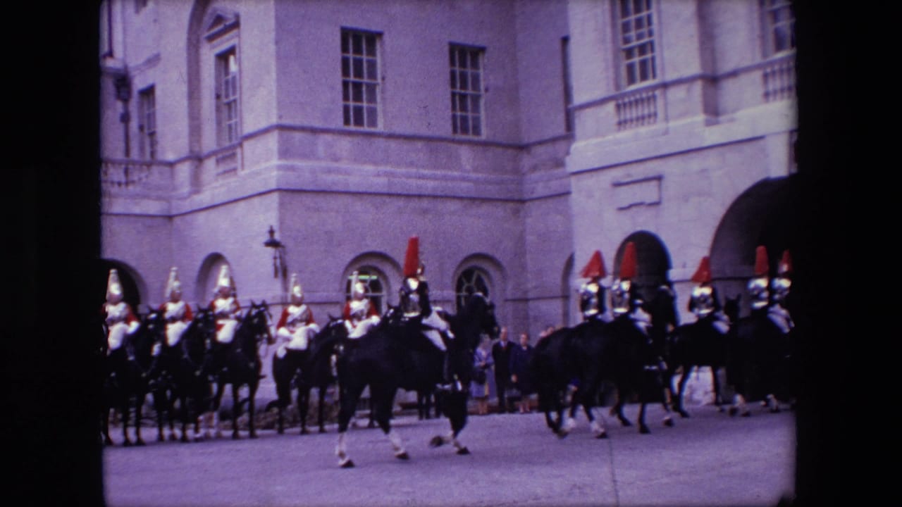 In London archival home-movie footage from the supplied 1967 metadata, mounted ceremonial guards pass a pale stone facade while spectators stand near the edges.