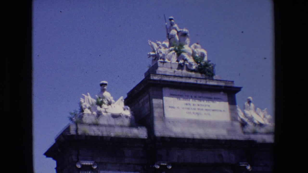 Top of a stone monument with carved figures and a partially visible inscription.