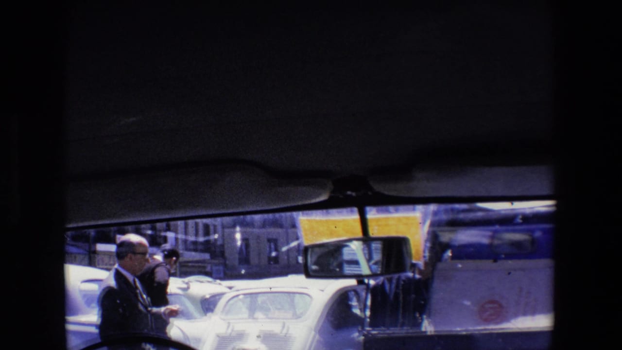 Pedestrians beside cars and a white service vehicle on a busy street.