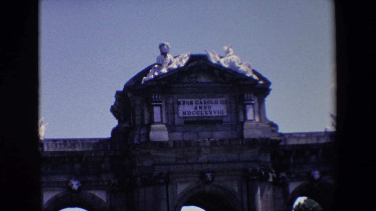 Closer view of the upper section of a stone gate with inscription and sculpted figures.