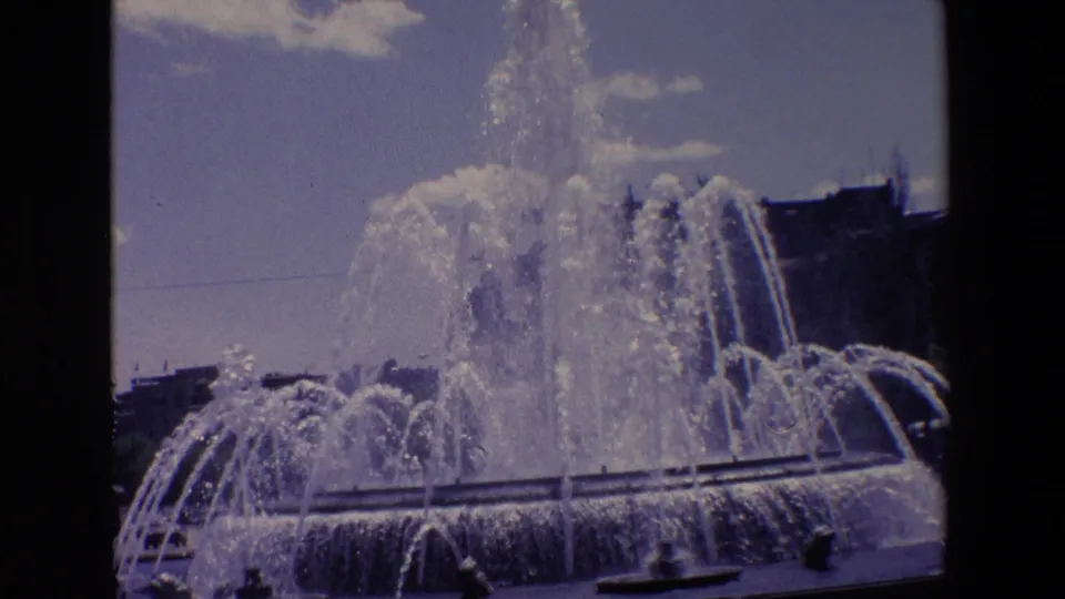1967 Madrid frame with the fountain filling most of the view, dense water spray rising above the basin, and dark rounded film borders around the image.