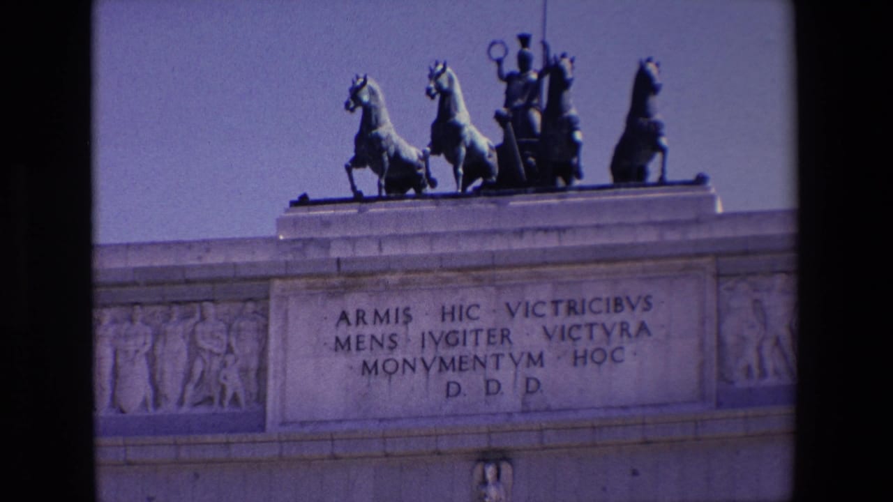 Closer view of the arch top with Latin inscription and rooftop horses.