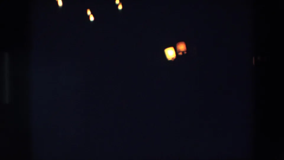 1967 Palermo closing frame with several dim yellow and red points of light separated across a near-black 8mm image.