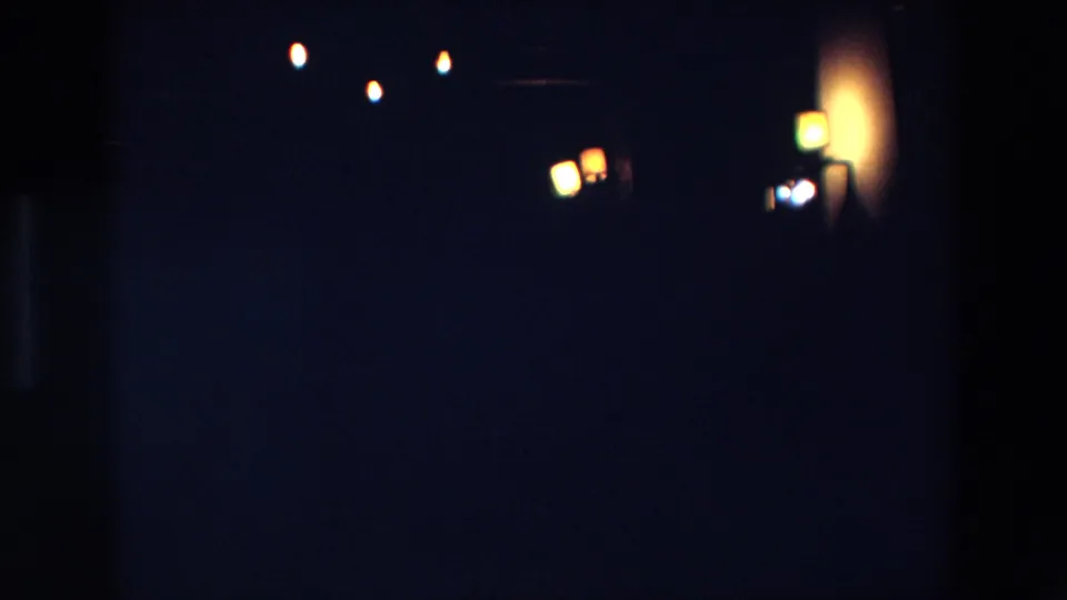 1967 Palermo 8mm night frame with clustered yellow-orange lamps near dark vertical shapes and broad shadowed areas.