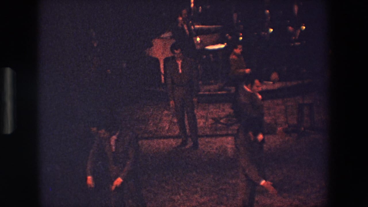 The final frame shows suited men in a dark Palermo interior during a repeated movement sequence, with one man bending low near the patterned floor.