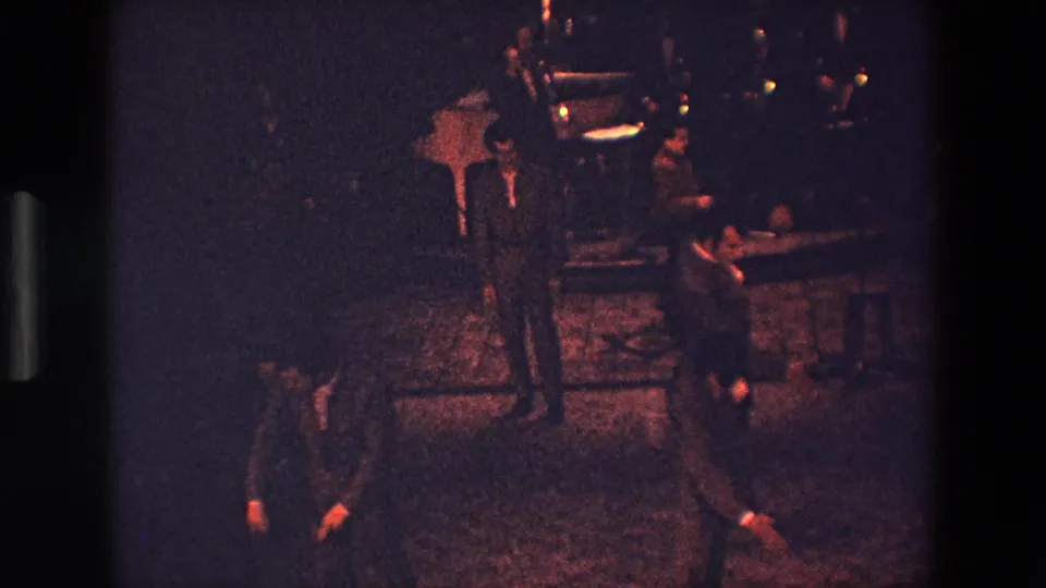 The final frame shows suited men in a dark Palermo interior during a repeated movement sequence, with one man bending low near the patterned floor.