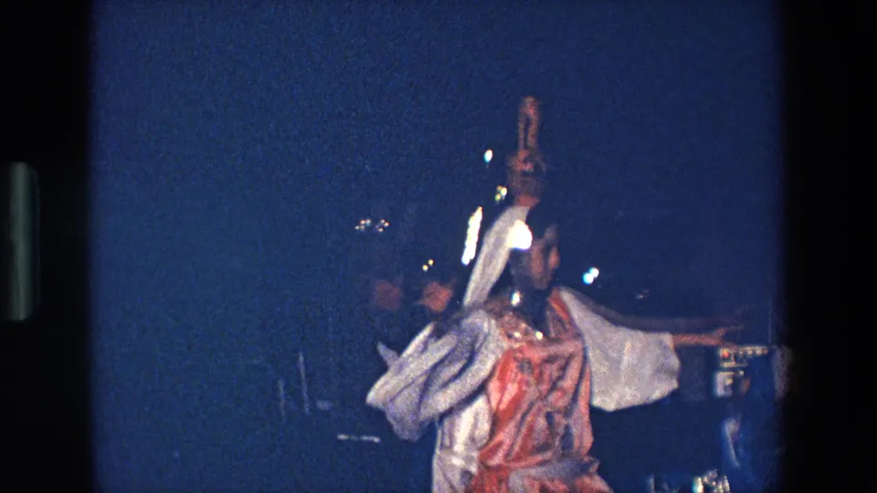 The final frame shows the woman in profile with one arm raised, her reflective costume details catching light on the dim Palermo stage.