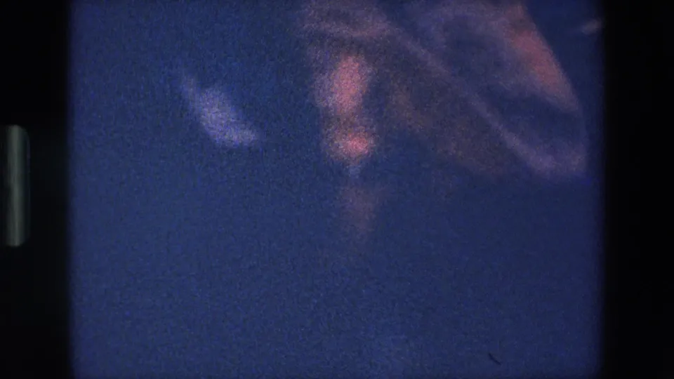 The Palermo 8mm frame becomes blurred and underexposed as the camera catches motion from the robed performer in blue-tinted night light.