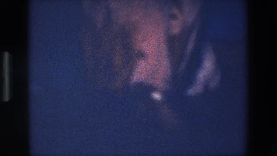 A heavily blurred 1967 Palermo frame shows close movement from the nighttime performance, with red and white tones partly visible through dense grain.