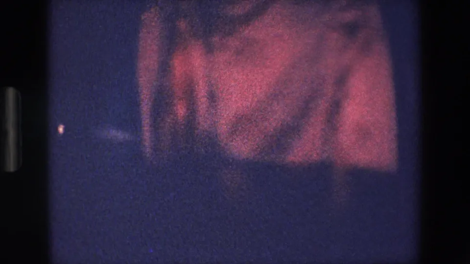 At the end of the 1967 Palermo clip, pink skirt fabric wraps or swirls around a woman’s lower body against a dark blue, heavily grained background.
