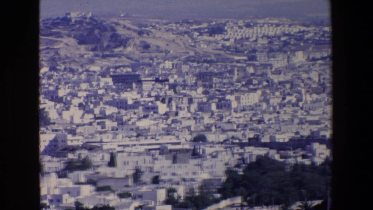 1967 Palermo view from a hillside or overlook, showing crowded urban blocks below a distant ridge and a prominent landmark on higher ground.