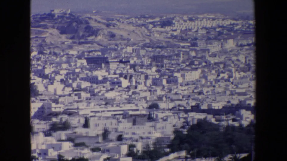 1967 Palermo view from a hillside or overlook, showing crowded urban blocks below a distant ridge and a prominent landmark on higher ground.
