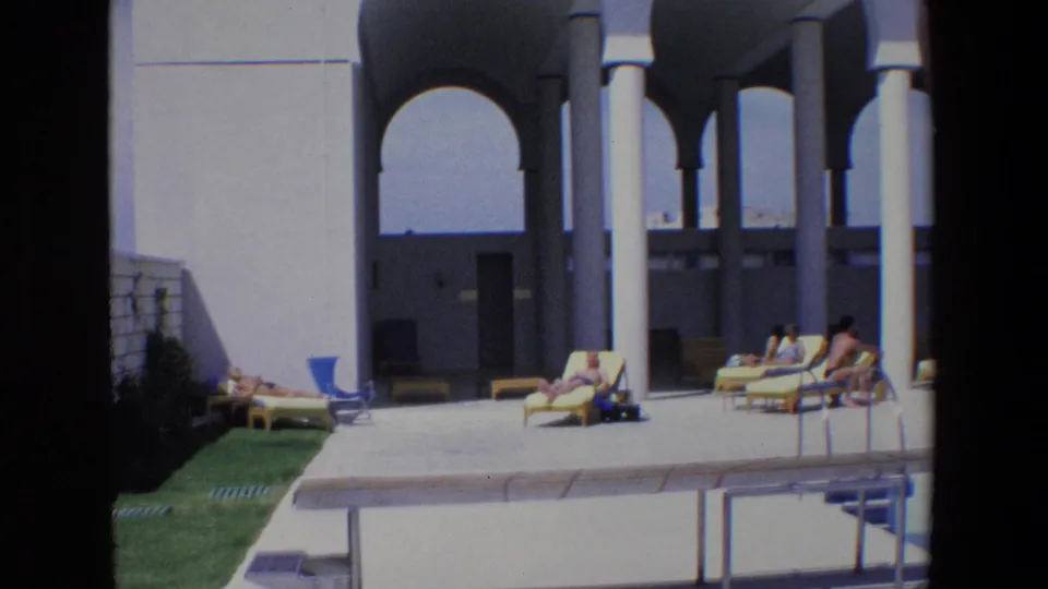 A 1967 Palermo pool deck scene with reclining and seated figures, yellow and blue lounge chairs, white columns, arches, and a small grass strip.