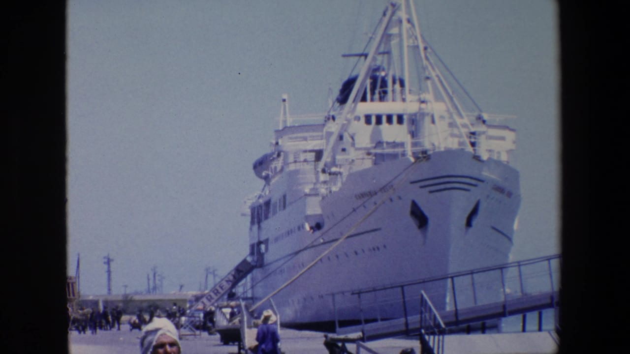 1967 Palermo 8mm frame of a docked white cruise or passenger ship, seen from the pier with boarding ramp, railings, and visitors below.