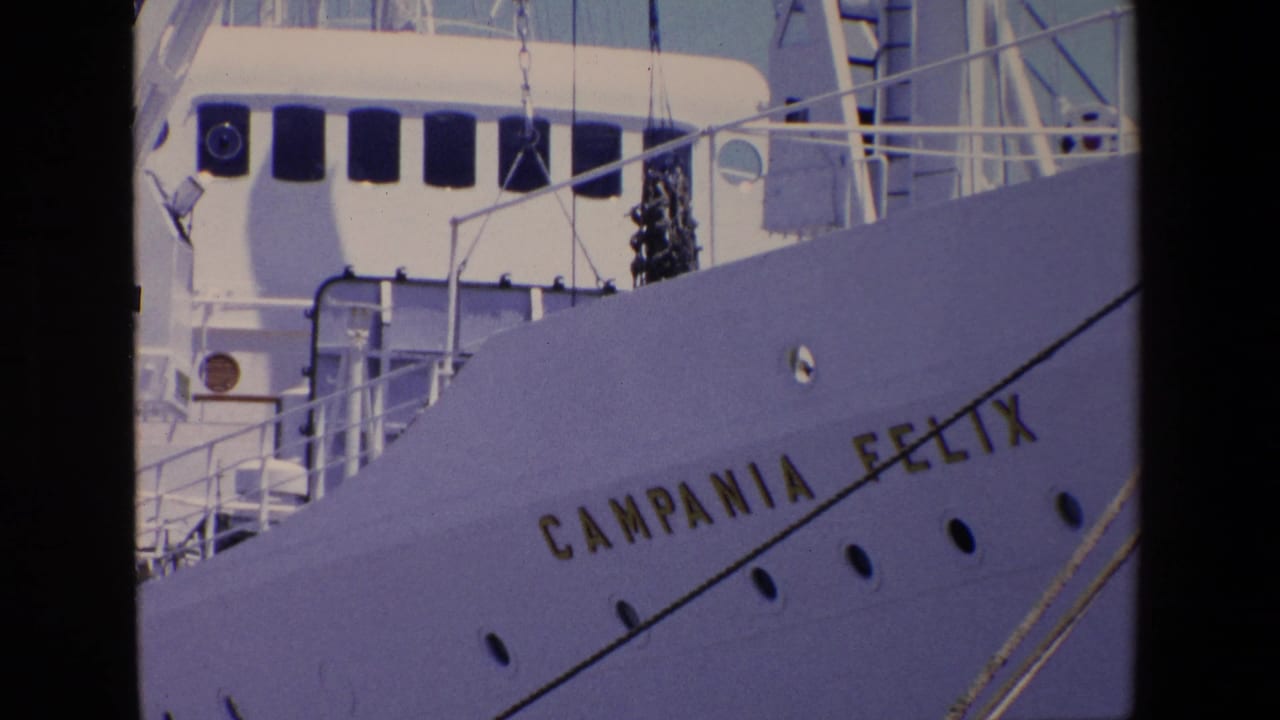 1967 Palermo port frame showing the white bow of the Campania Felix with gold lettering, portholes, railings, and upper deck structures.