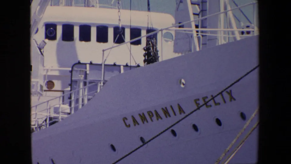 1967 Palermo port frame showing the white bow of the Campania Felix with gold lettering, portholes, railings, and upper deck structures.