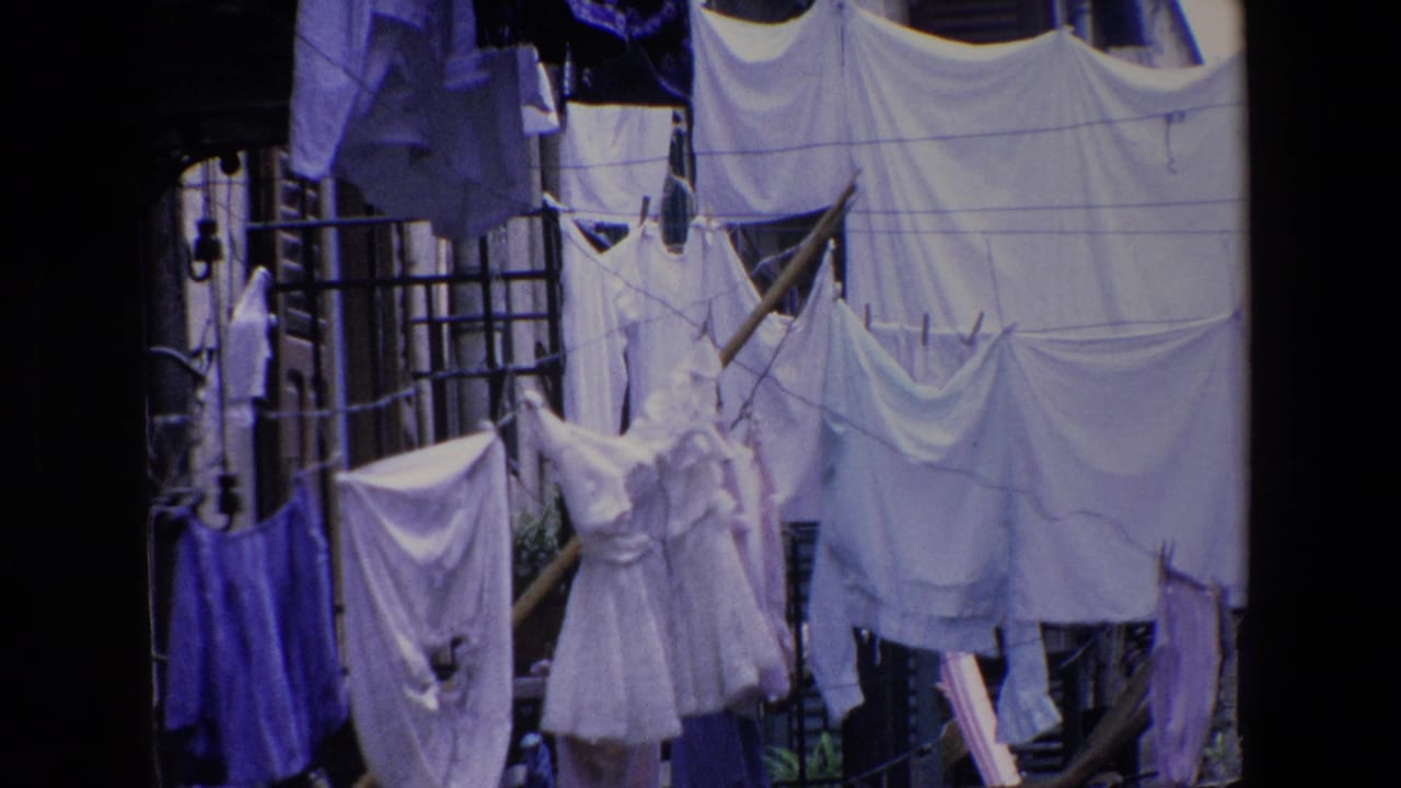 Outdoor laundry in Palermo, Italy, with dresses, shirts, sheets, and clothespins filling the frame in faded 8mm color.